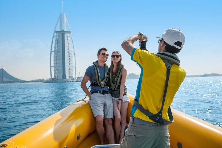 Experience the beauty of Dubai's skyline as you cruise on a speedy boat capturing memories with stunning landmarks like the Burj Al Arab in the background. Perfect for adventurers!